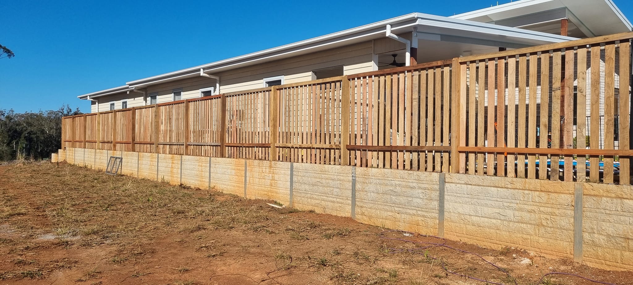Picket fence on stone retaining wall